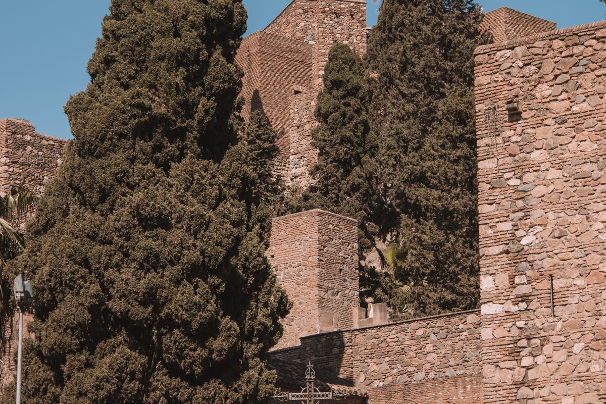 Remparts de pierre de l'Alcazaba de Málaga sous un ciel dégagé