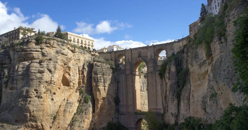 Le Puente Nuevo de Ronda sur le Tajo, vu d'en bas, avec les maisons au bord de l'à-pic