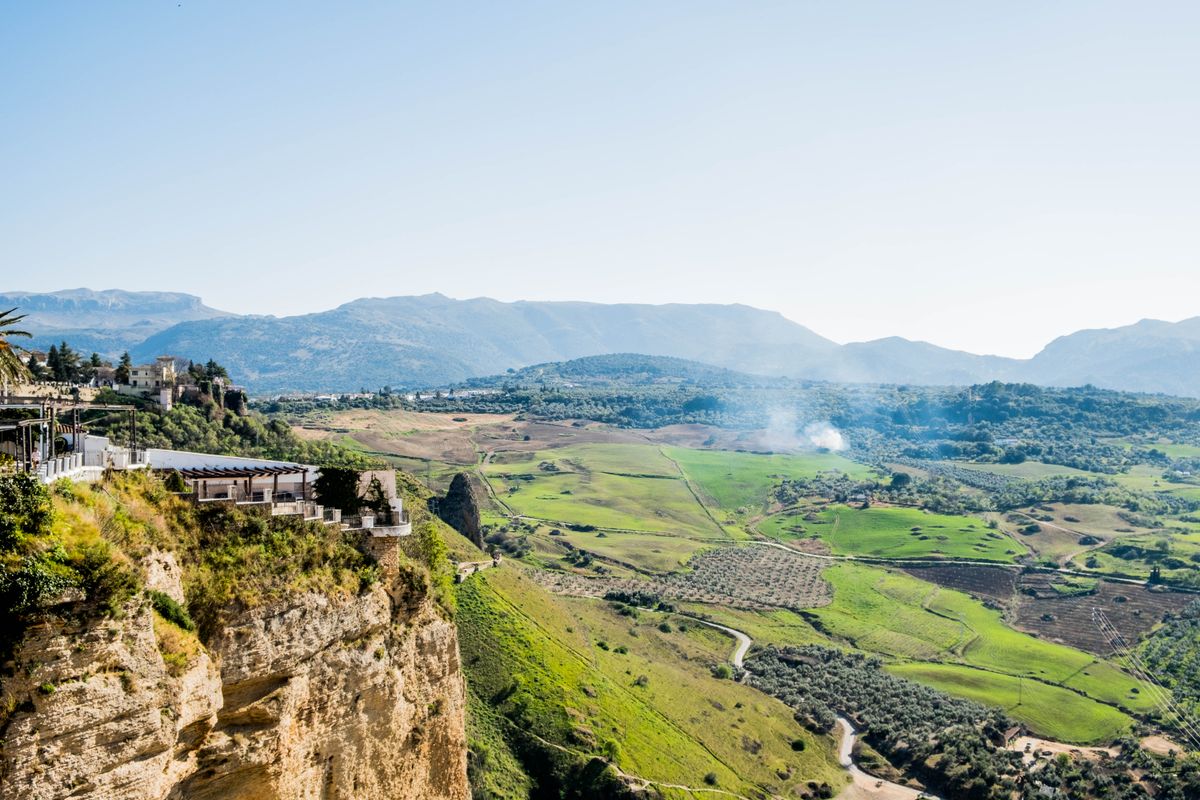 À-pic de Ronda avec une terrasse au bord et la plaine et la Serranía de Ronda au fond
